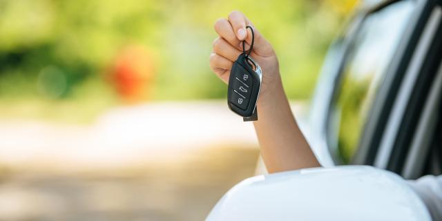 girl-sitting-in-the-car-and-holding-the-car-keys-hands-out-of-the-car.jpg